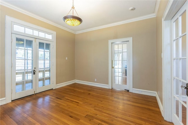 interior space with french doors, wood-type flooring, and ornamental molding