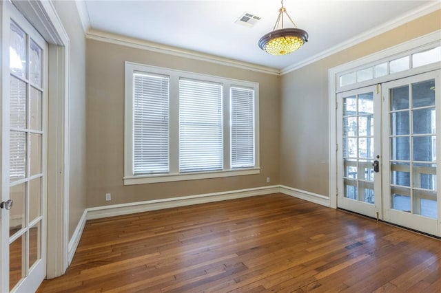 empty room featuring dark hardwood / wood-style floors, crown molding, and french doors