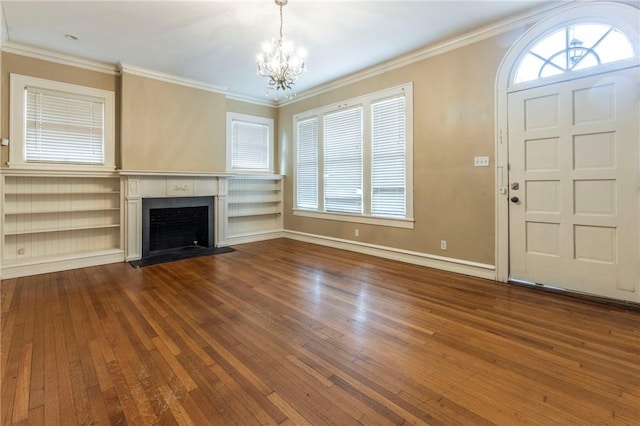 unfurnished living room featuring hardwood / wood-style floors, ornamental molding, and a notable chandelier