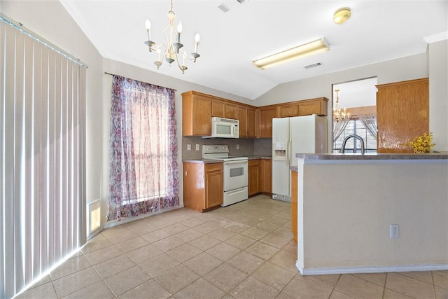 kitchen featuring white appliances, an inviting chandelier, and plenty of natural light