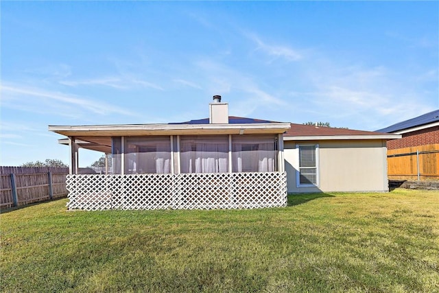 back of property with a sunroom and a yard