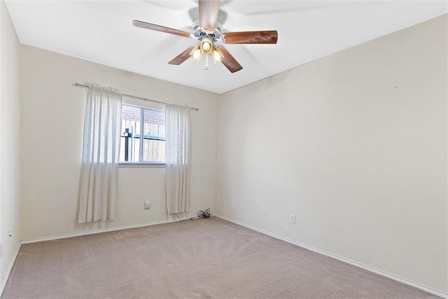 spare room with light colored carpet and ceiling fan