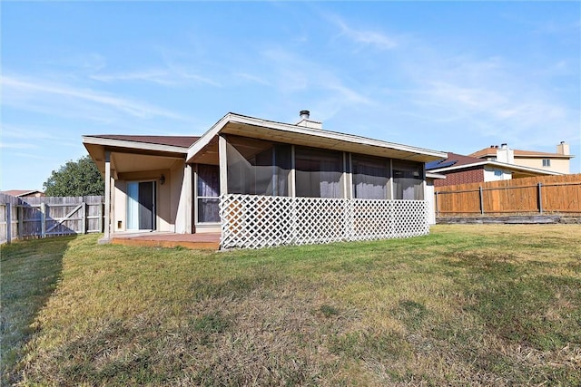 rear view of property featuring a lawn