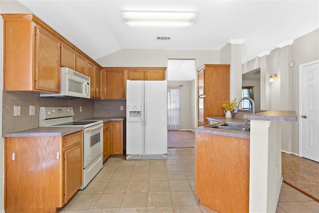 kitchen with sink, kitchen peninsula, vaulted ceiling, white appliances, and light tile patterned floors