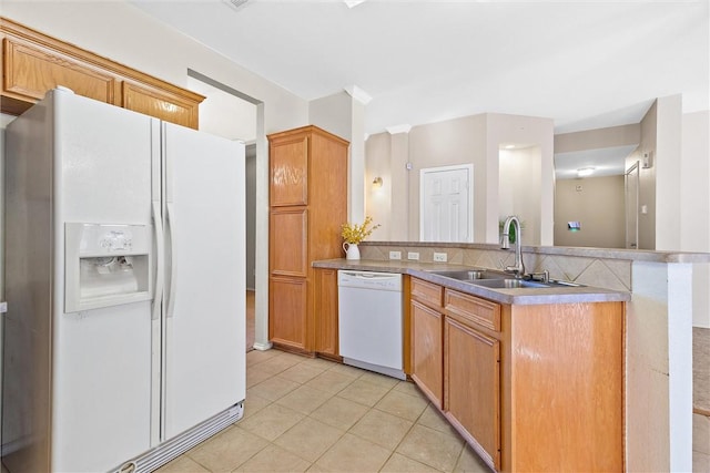 kitchen featuring kitchen peninsula, white appliances, sink, and light tile patterned floors