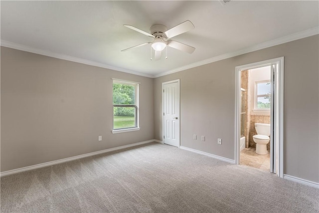 unfurnished bedroom with ceiling fan, ensuite bathroom, light colored carpet, a closet, and ornamental molding