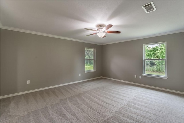 empty room featuring light colored carpet, a wealth of natural light, and crown molding