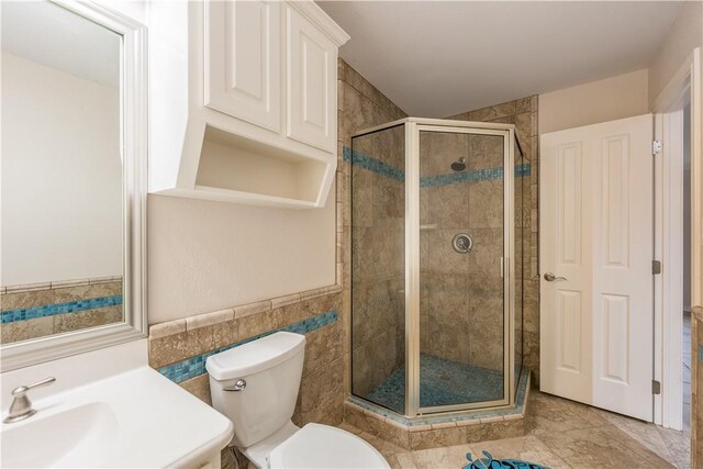 bathroom featuring walk in shower, toilet, tile walls, and sink