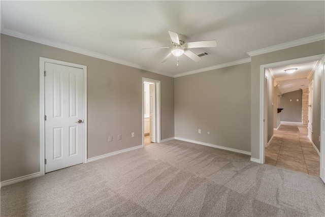 spare room featuring ceiling fan, light colored carpet, and crown molding