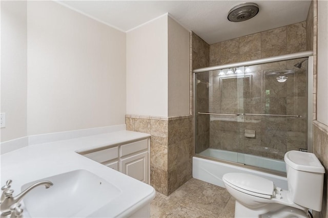 full bathroom featuring shower / bath combination with glass door, toilet, tile walls, and sink