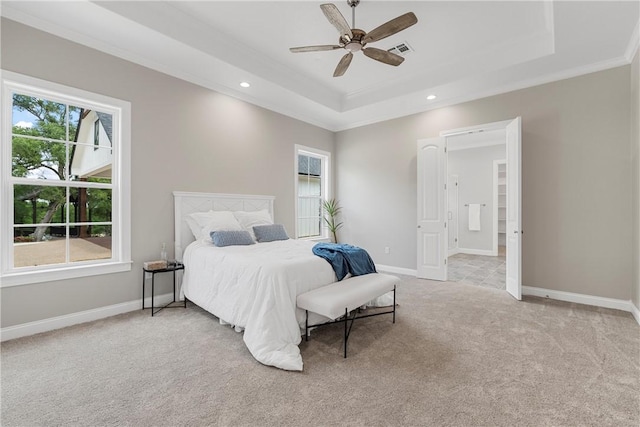 carpeted bedroom featuring a raised ceiling, ceiling fan, and crown molding