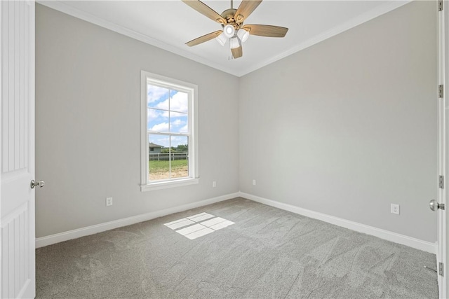 carpeted spare room featuring ceiling fan and crown molding