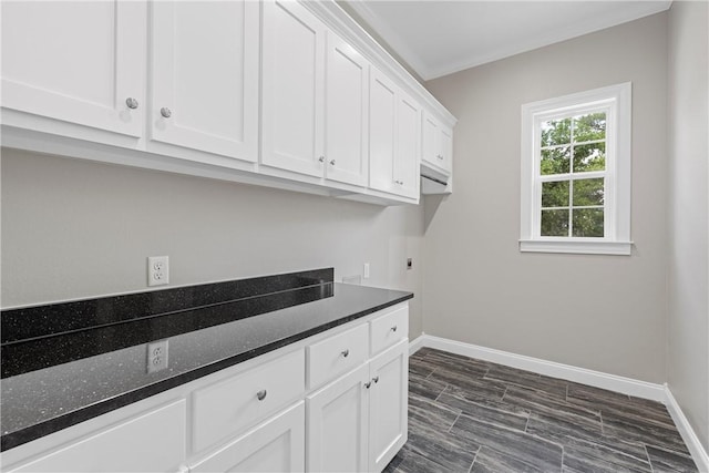 laundry area with hookup for an electric dryer, dark hardwood / wood-style floors, cabinets, and crown molding