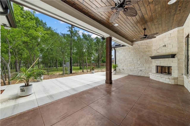 view of patio with an outdoor stone fireplace and ceiling fan