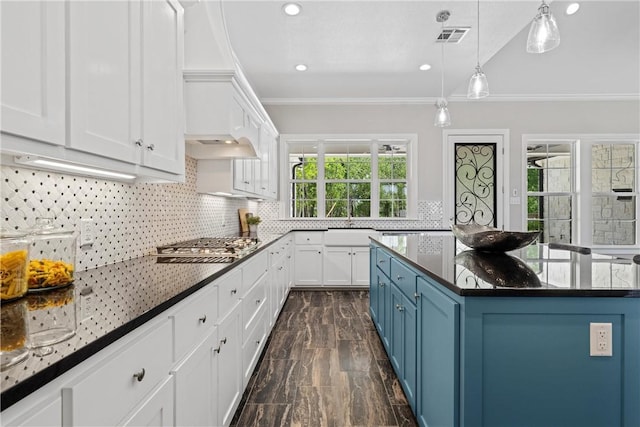 kitchen with blue cabinetry, white cabinetry, crown molding, decorative light fixtures, and stainless steel gas stovetop