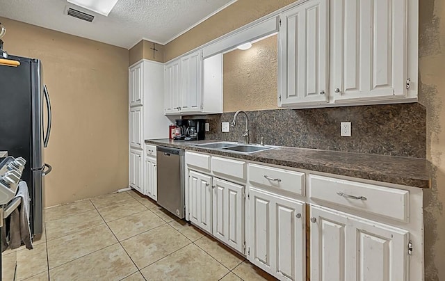 kitchen featuring white cabinetry, sink, stainless steel appliances, decorative backsplash, and light tile patterned floors