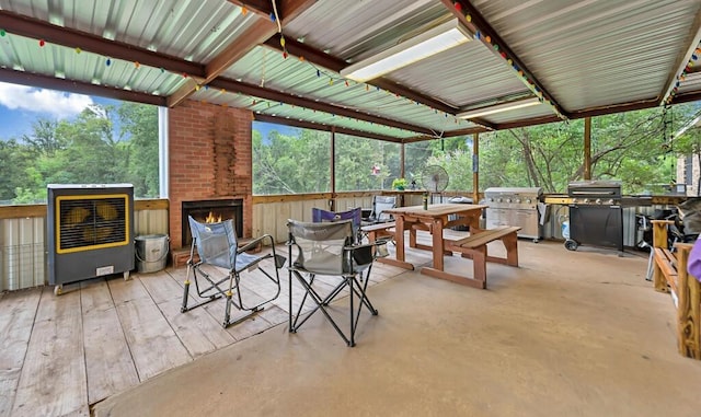 view of patio featuring heating unit and a brick fireplace