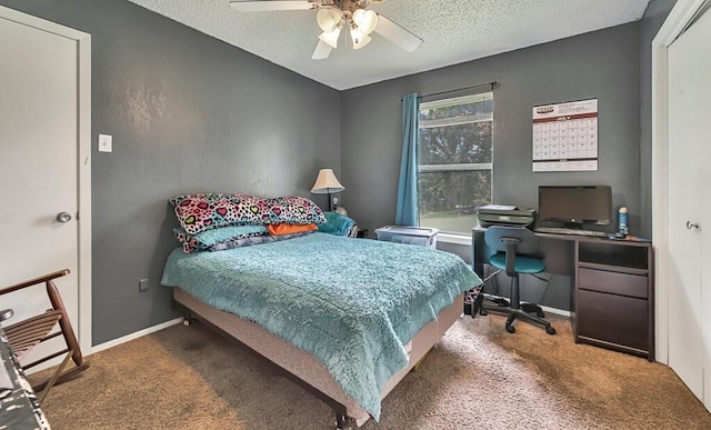 carpeted bedroom with ceiling fan and a textured ceiling