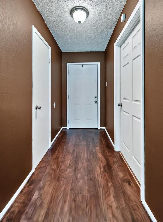 entryway with a textured ceiling and dark wood-type flooring