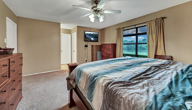 carpeted bedroom with ceiling fan and a textured ceiling