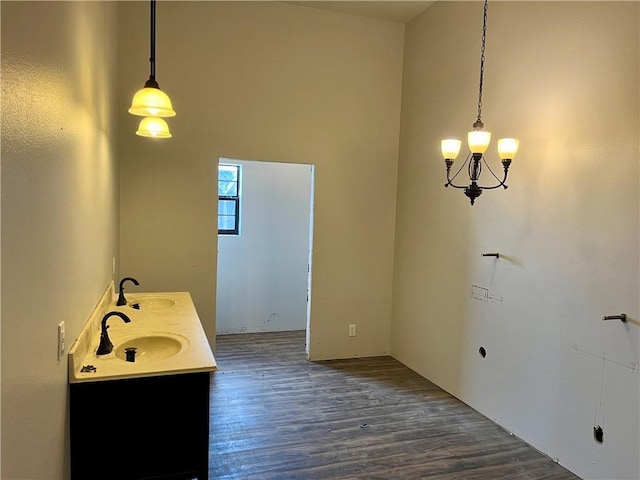 bathroom featuring a chandelier, a high ceiling, hardwood / wood-style flooring, and sink