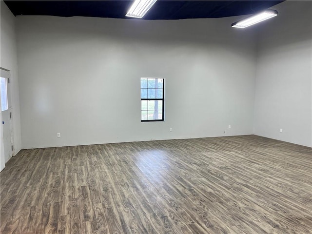 unfurnished room with hardwood / wood-style floors and a high ceiling