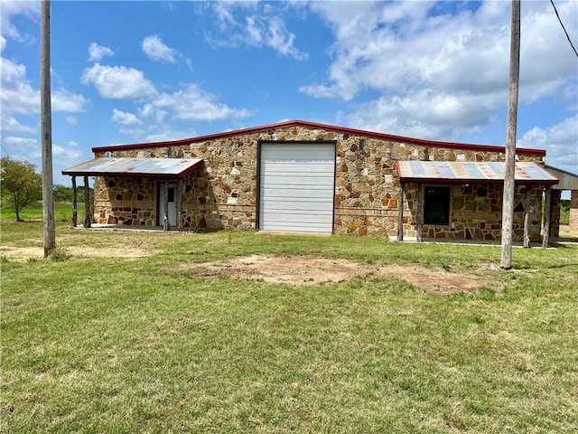 back of property featuring a lawn and a garage