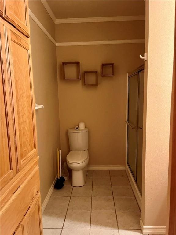 bathroom with tile patterned floors, toilet, an enclosed shower, and crown molding