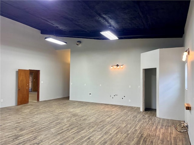 unfurnished room with wood-type flooring and a high ceiling