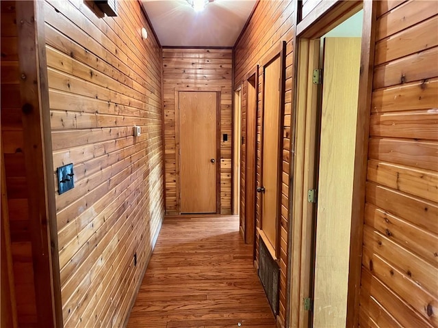 corridor with hardwood / wood-style flooring and wood walls