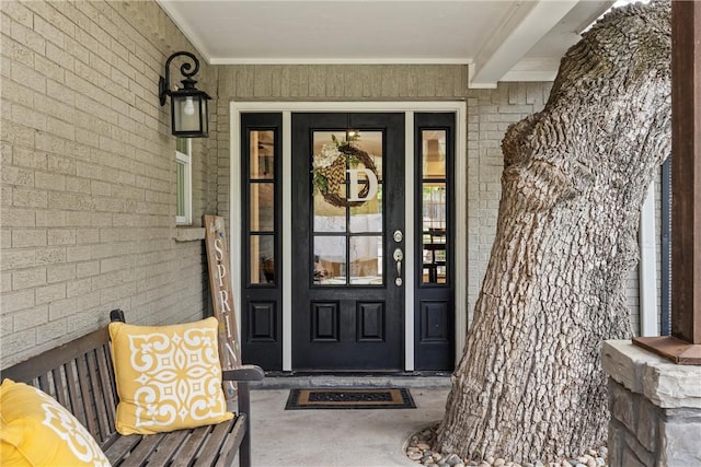 view of exterior entry featuring brick siding