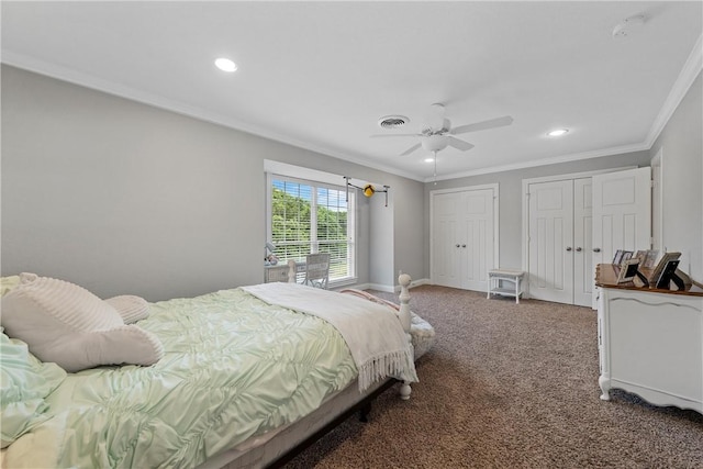 bedroom with carpet flooring, two closets, visible vents, and crown molding