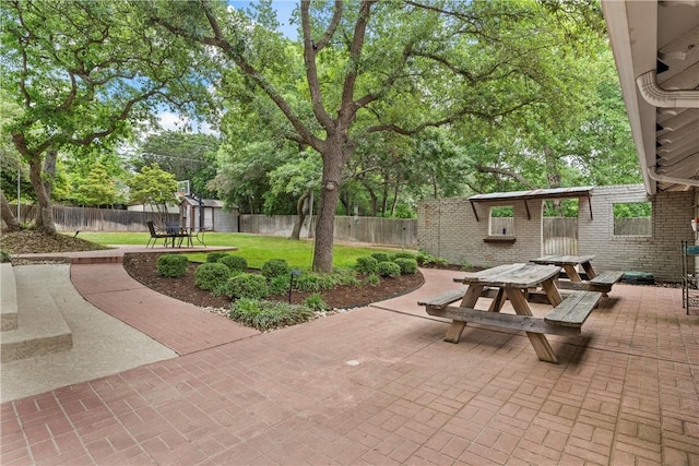 view of patio / terrace featuring a fenced backyard, a shed, outdoor dining area, and an outbuilding