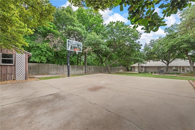 view of basketball court featuring basketball hoop and fence