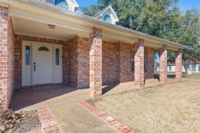 doorway to property with brick siding