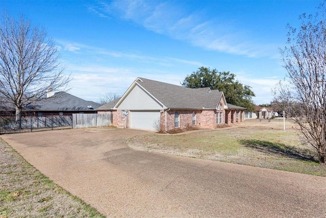 view of front of home with a garage, driveway, brick siding, fence, and a front yard