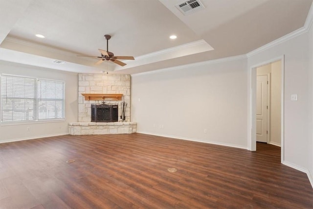 unfurnished living room with dark wood-style flooring, a fireplace, a raised ceiling, visible vents, and a ceiling fan