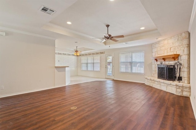 unfurnished living room featuring visible vents, a tray ceiling, and dark wood finished floors