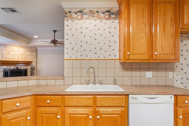 kitchen featuring visible vents, dishwasher, ornamental molding, light countertops, and a sink