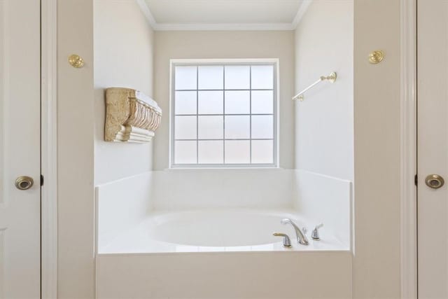 bathroom with a garden tub, a wealth of natural light, and crown molding