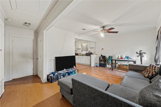 living room with hardwood / wood-style floors, ceiling fan, and ornamental molding