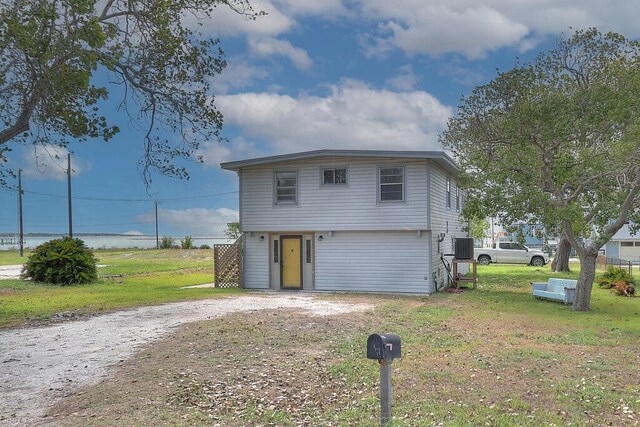 view of front facade featuring a front lawn and cooling unit