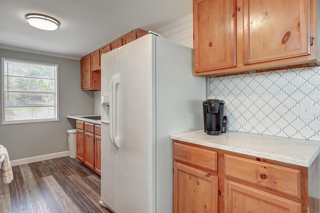 kitchen featuring dark hardwood / wood-style flooring, tasteful backsplash, white fridge with ice dispenser, and crown molding