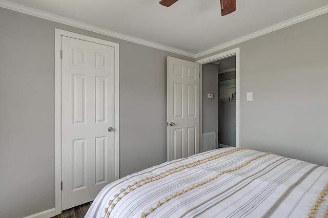 bedroom featuring dark wood-type flooring, ceiling fan, and ornamental molding