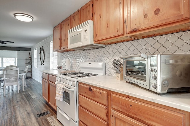 kitchen with backsplash, ceiling fan, dark hardwood / wood-style floors, and white appliances