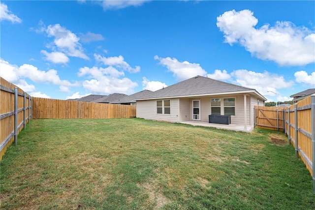 rear view of house featuring a patio area and a yard