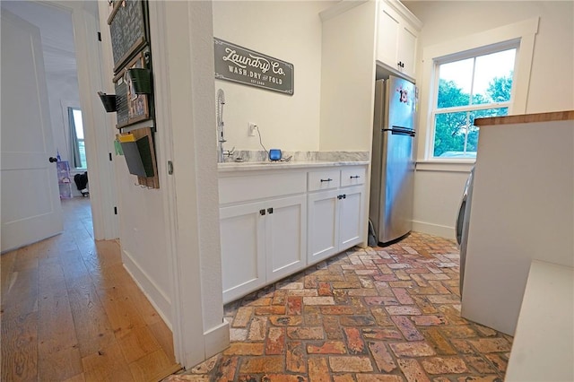 kitchen featuring white cabinets and stainless steel refrigerator