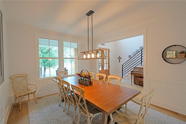 dining room with light wood-type flooring and ornamental molding