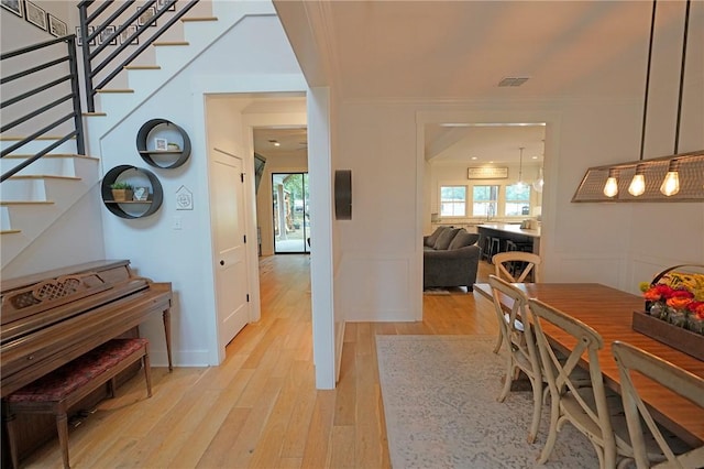 dining space featuring crown molding and light hardwood / wood-style floors