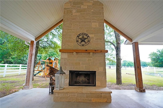 view of patio / terrace with a playground and an outdoor stone fireplace